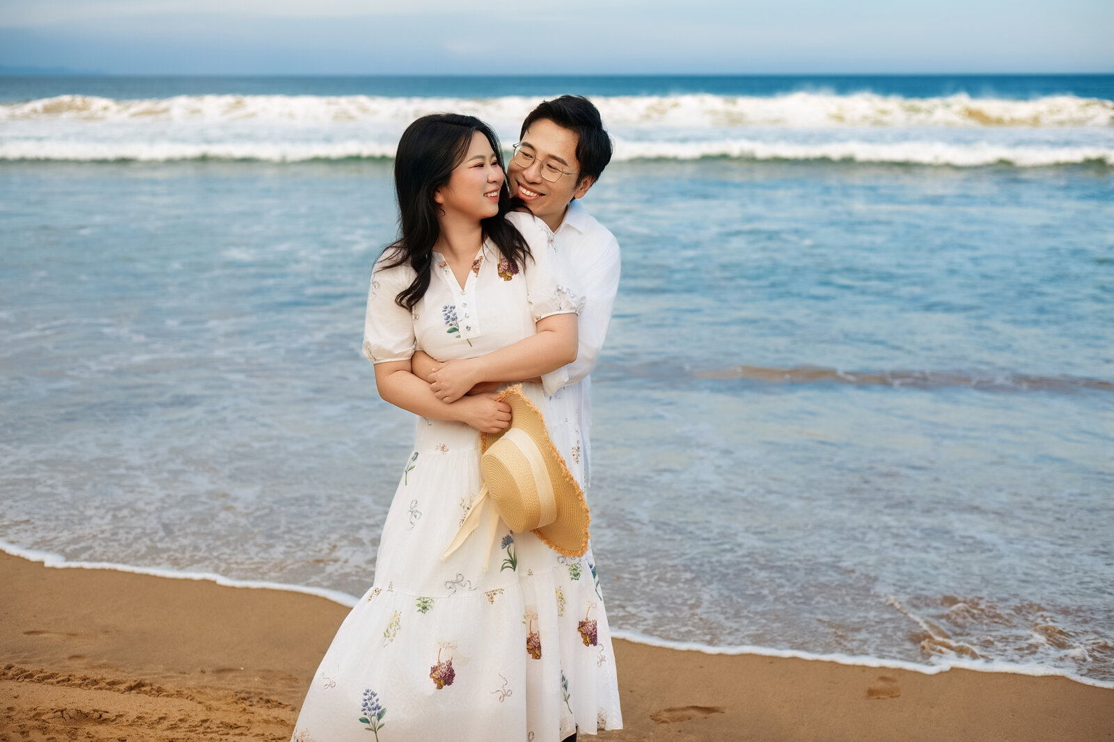 新人在海浪前相拥